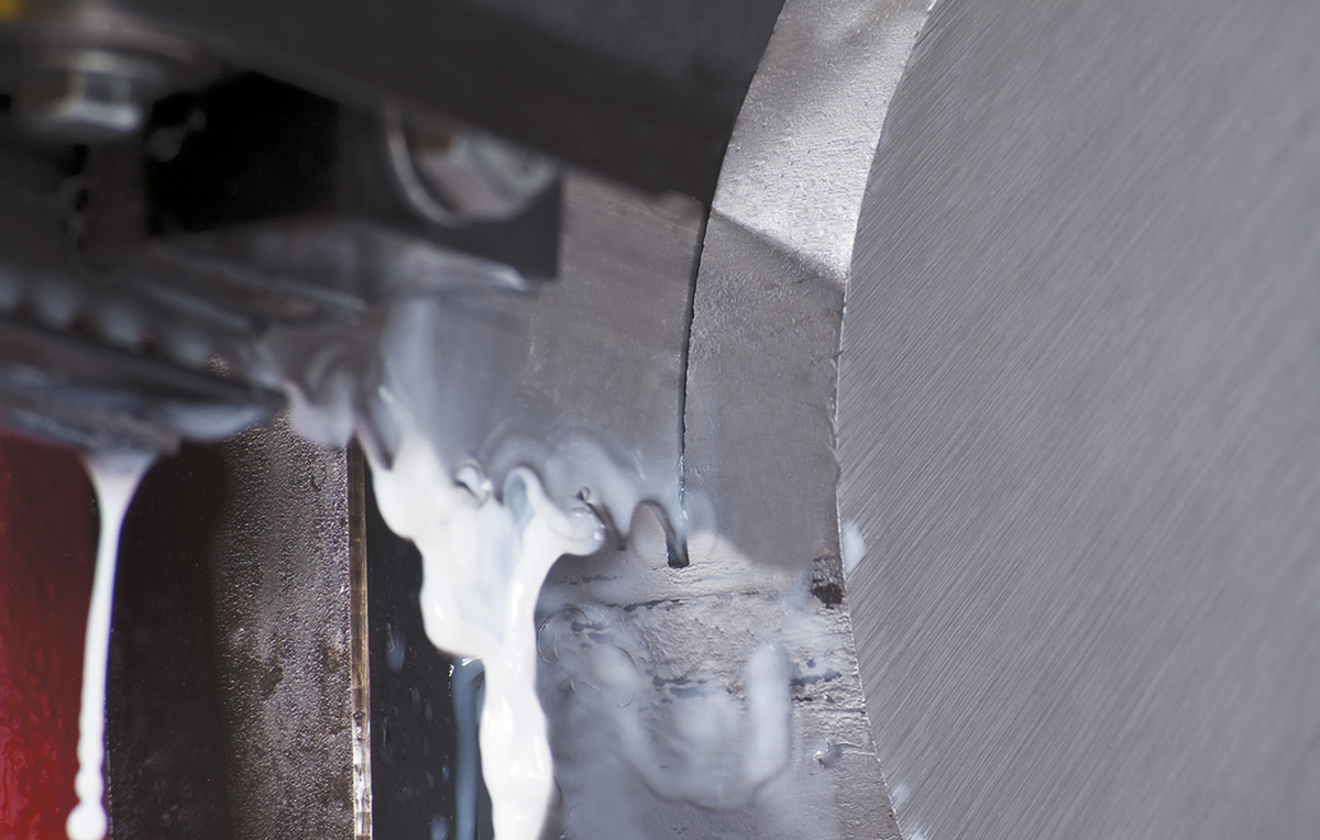 Disc of metal being cut by a serrated blade