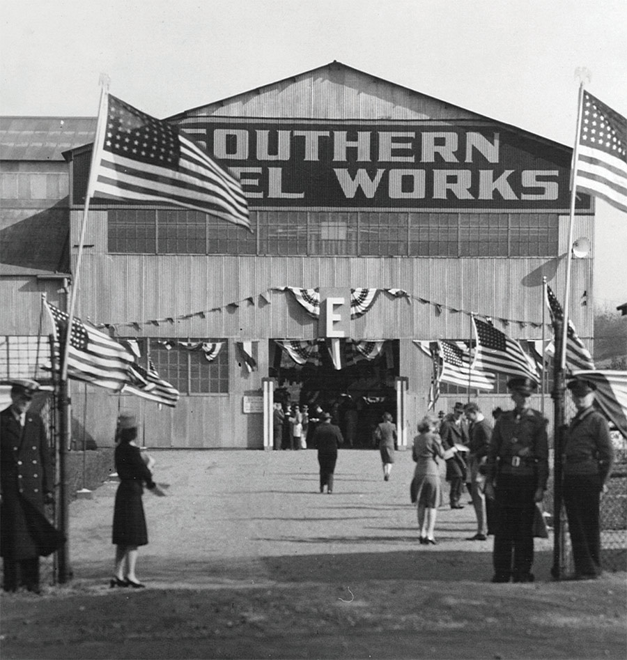 old photo of Southern Steel Works with people and American flags out front