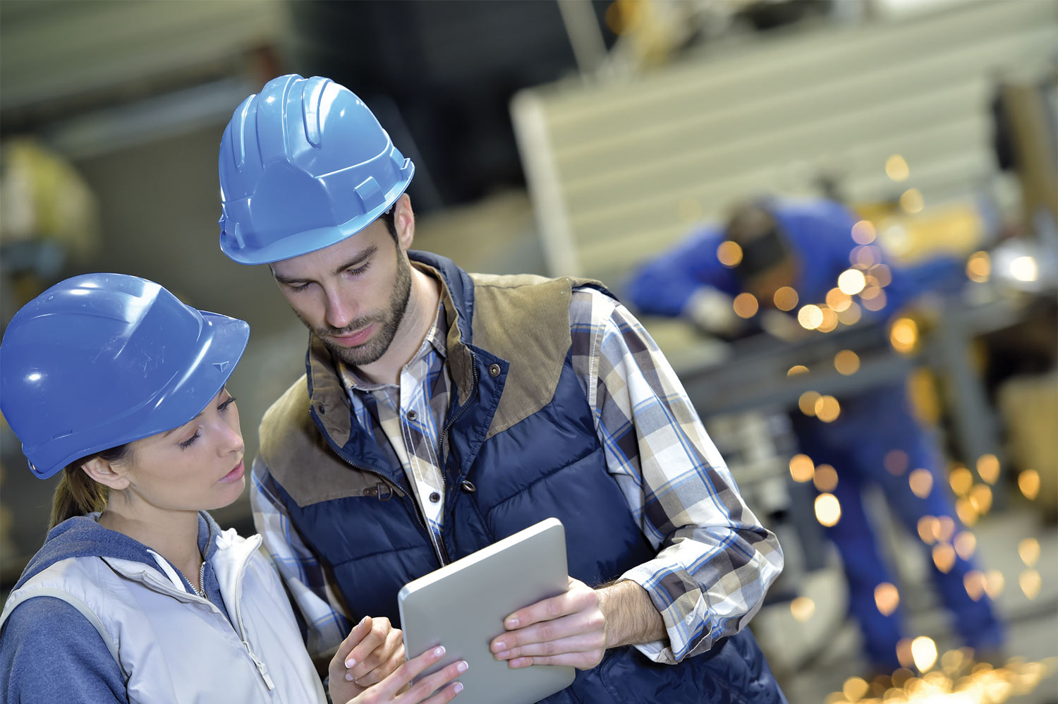 two industrial workers talking over an iPad